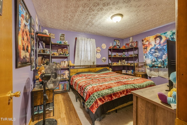 bedroom featuring a textured ceiling and wood finished floors