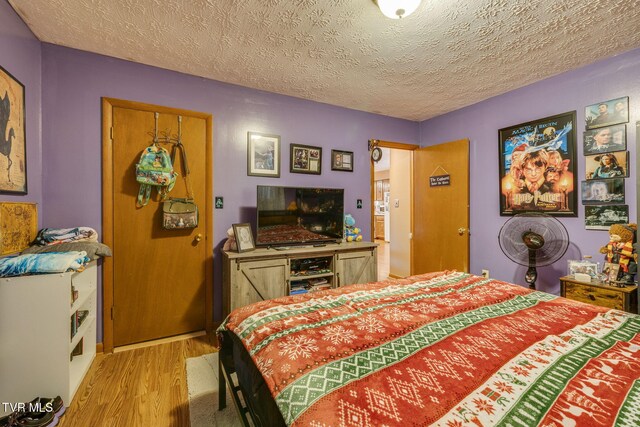 bedroom featuring a textured ceiling and wood finished floors