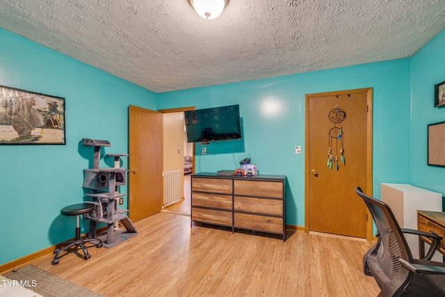 office space with wood finished floors, baseboards, and a textured ceiling