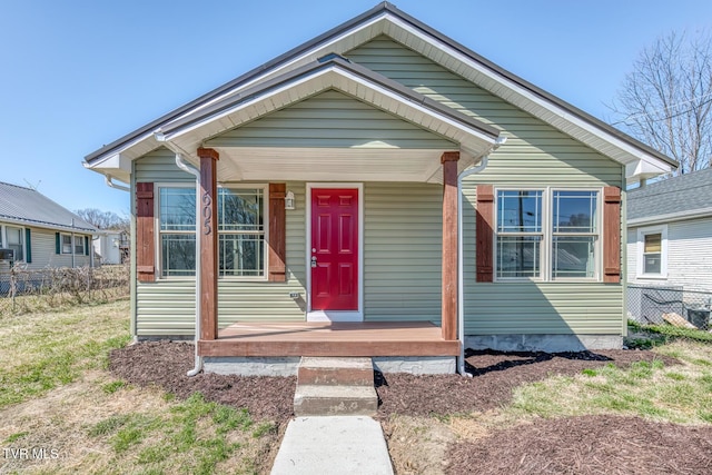 bungalow featuring covered porch and fence