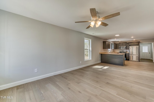 unfurnished living room featuring recessed lighting, baseboards, light wood-style flooring, and ceiling fan