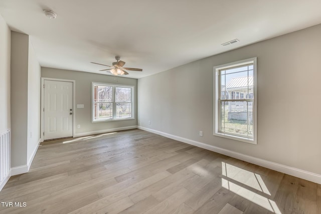 spare room featuring visible vents, light wood-style flooring, baseboards, and ceiling fan