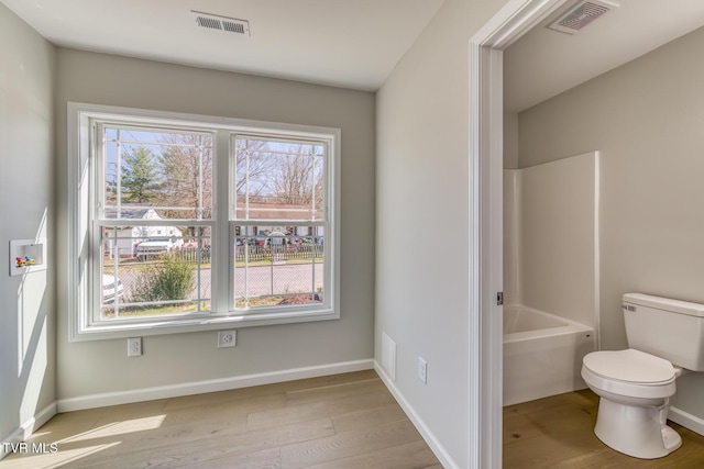 bathroom featuring visible vents, baseboards, toilet, and wood finished floors