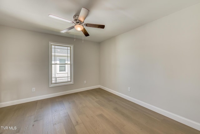 unfurnished room featuring baseboards, wood finished floors, and a ceiling fan