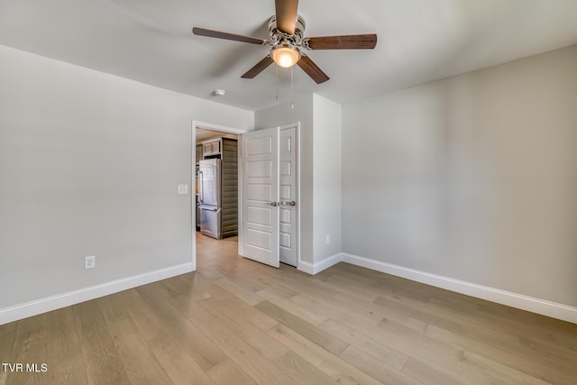 unfurnished bedroom featuring baseboards, light wood-style flooring, a ceiling fan, and freestanding refrigerator