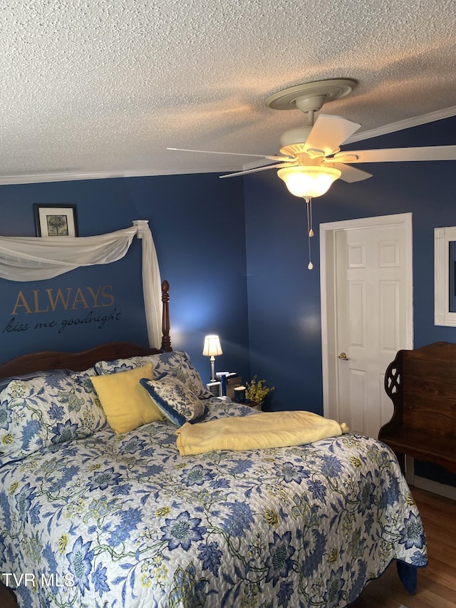 bedroom with a textured ceiling, wood finished floors, and a ceiling fan