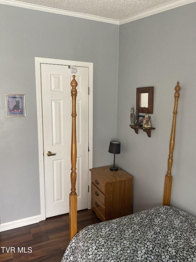 bedroom with baseboards, dark wood-type flooring, crown molding, and a textured ceiling