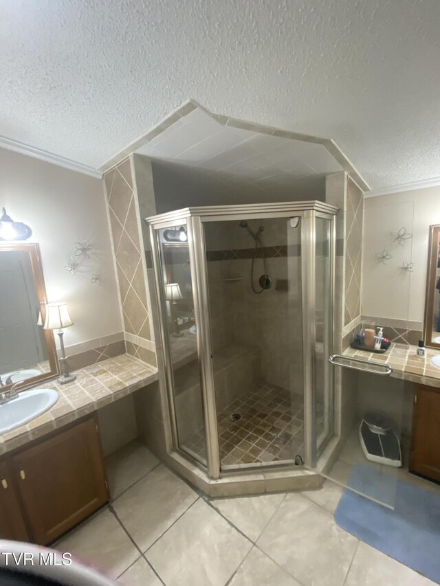 bathroom with vanity, tile patterned floors, a stall shower, and a textured ceiling