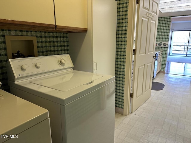 clothes washing area with cabinet space and washer and dryer