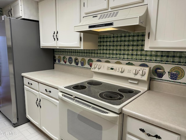 kitchen with under cabinet range hood, light countertops, freestanding refrigerator, white cabinets, and white electric stove