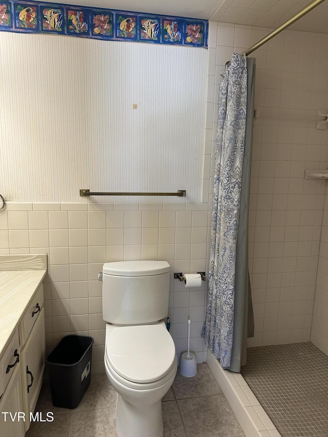 full bath featuring vanity, tile patterned floors, tile walls, and a stall shower