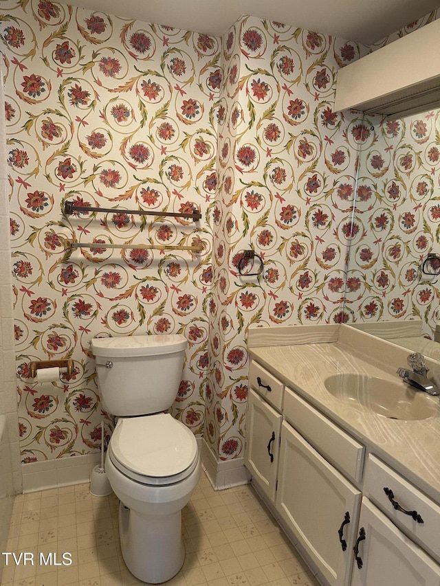 bathroom with vanity, tile patterned floors, toilet, and baseboards