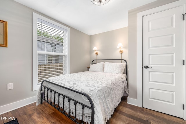 bedroom with wood finished floors and baseboards