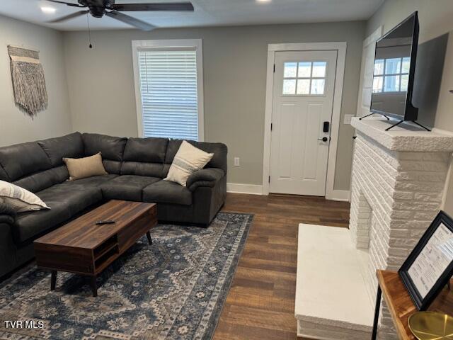 living area featuring ceiling fan, baseboards, and wood finished floors