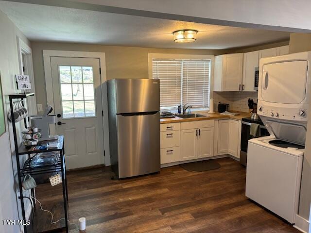 kitchen featuring dark wood finished floors, freestanding refrigerator, a sink, range with electric cooktop, and white cabinetry