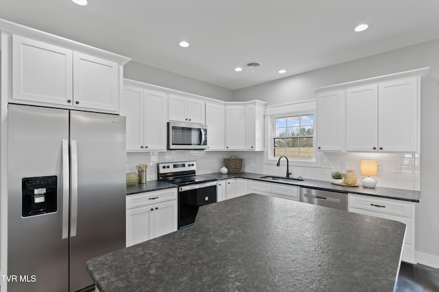 kitchen featuring recessed lighting, a sink, white cabinets, appliances with stainless steel finishes, and backsplash