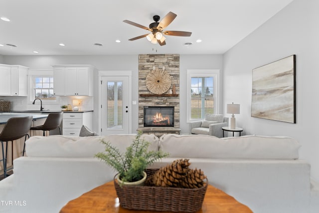 living area with a ceiling fan, recessed lighting, and a fireplace