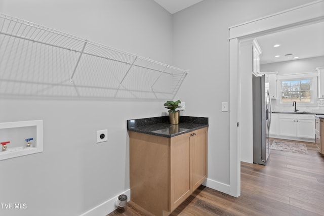 laundry area with hookup for a washing machine, wood finished floors, laundry area, a sink, and electric dryer hookup