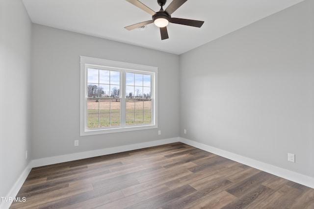 empty room featuring ceiling fan, baseboards, and dark wood-style flooring