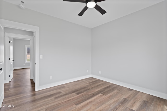 unfurnished room with ceiling fan, baseboards, and wood finished floors