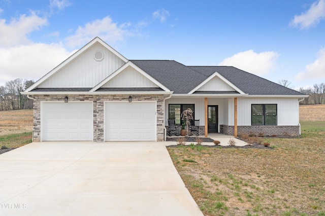 view of front of property with driveway, a porch, roof with shingles, a front yard, and an attached garage