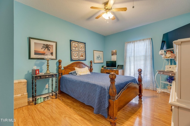 bedroom with ceiling fan, baseboards, a textured ceiling, and wood finished floors