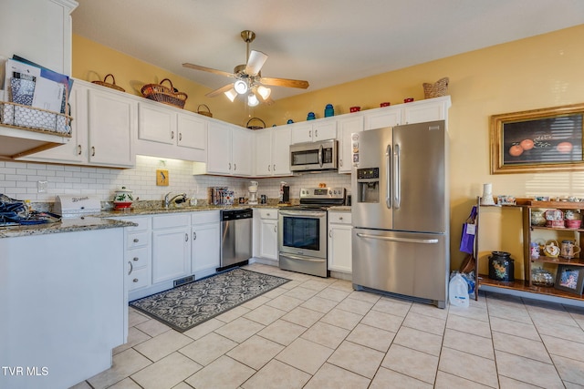 kitchen with decorative backsplash, white cabinets, appliances with stainless steel finishes, and a sink