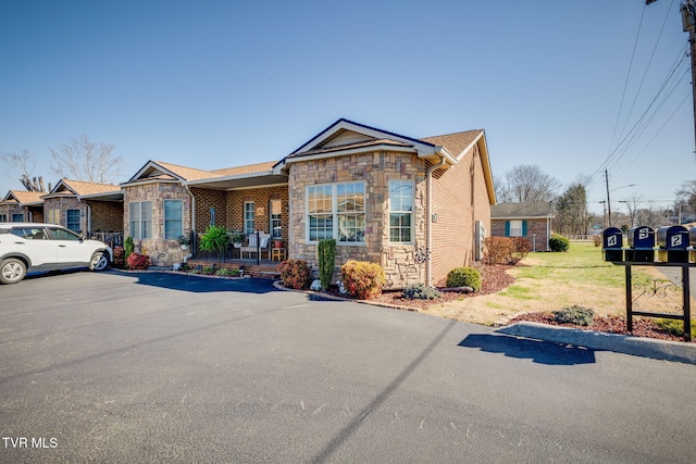 view of front of home with stone siding and a front lawn