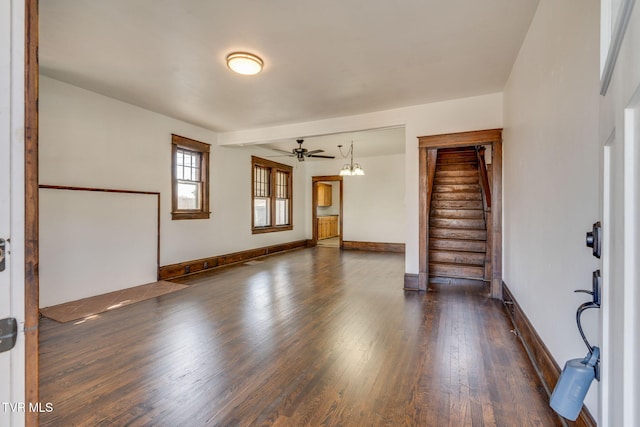 unfurnished room featuring stairs, wood finished floors, baseboards, and a ceiling fan