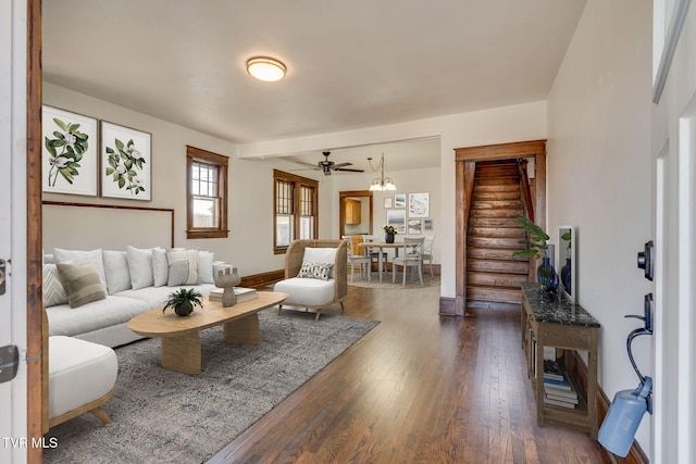 living room featuring dark wood finished floors, stairway, baseboards, and ceiling fan