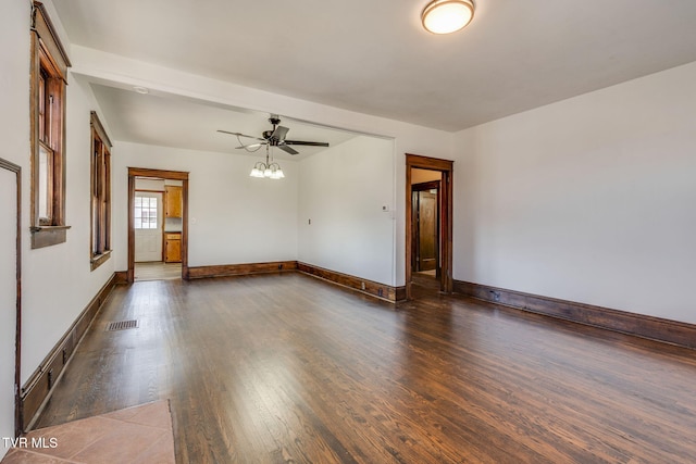 empty room featuring visible vents, baseboards, wood finished floors, and a ceiling fan