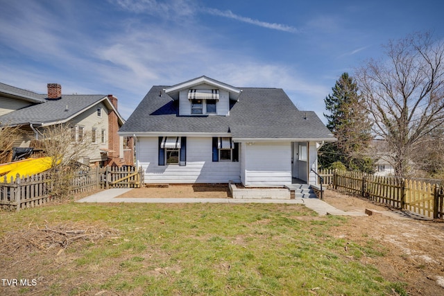 back of house with a yard, a shingled roof, a fenced backyard, and entry steps