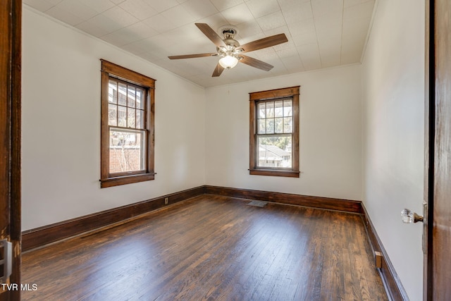 spare room with visible vents, ceiling fan, baseboards, and wood-type flooring