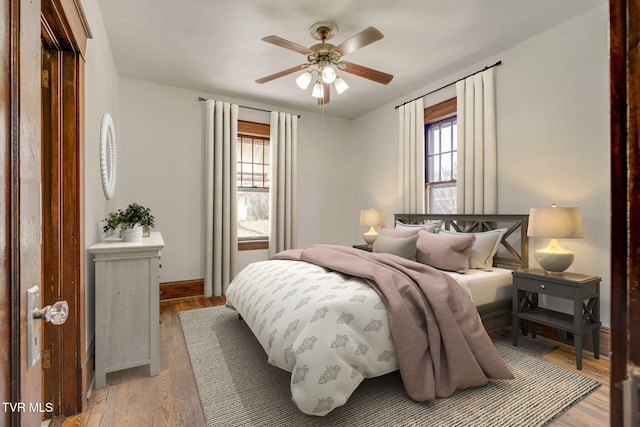 bedroom featuring a ceiling fan, light wood-style floors, and baseboards