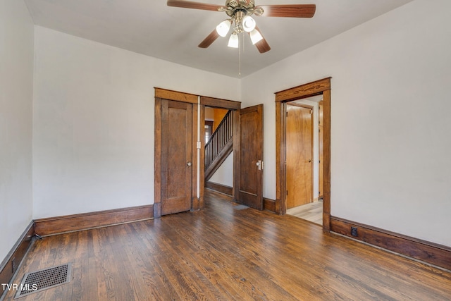 empty room with baseboards, wood finished floors, visible vents, and ceiling fan