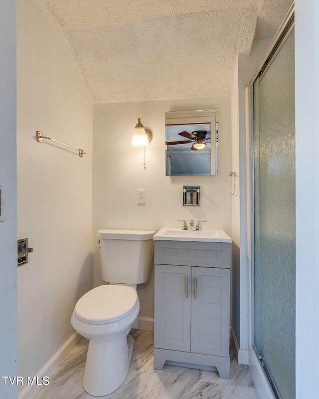 bathroom featuring vanity, toilet, baseboards, and a stall shower