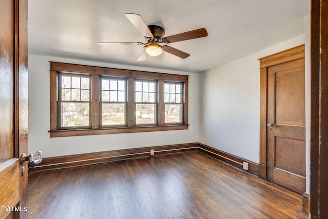 empty room featuring hardwood / wood-style flooring, a ceiling fan, and baseboards