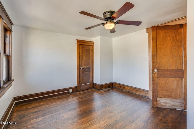 empty room with a ceiling fan, baseboards, and wood finished floors