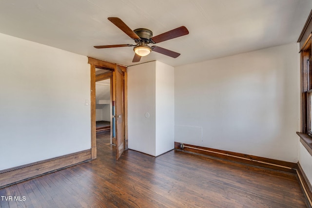 spare room featuring dark wood-style floors, baseboards, and ceiling fan