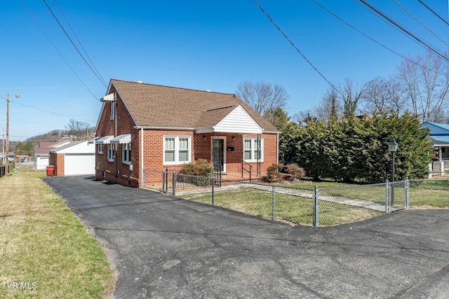 bungalow-style home featuring a fenced front yard, a front lawn, an outbuilding, and brick siding