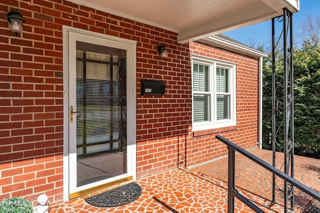 doorway to property with brick siding