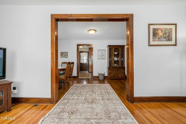 hallway featuring baseboards and wood finished floors