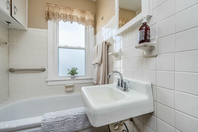 bathroom featuring a wealth of natural light, tile walls, and a sink