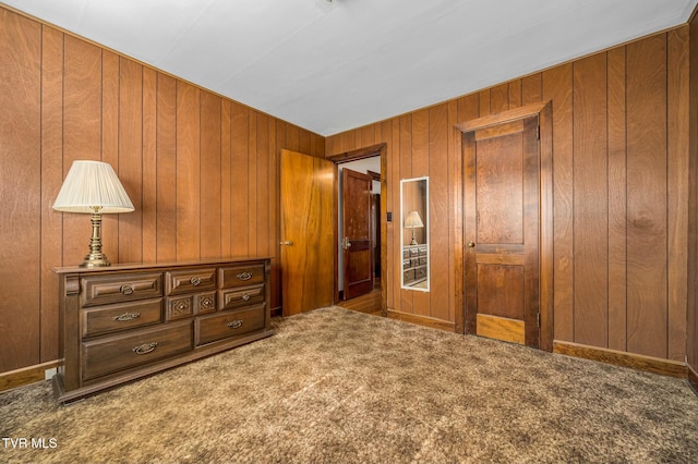 bedroom featuring wood walls and carpet floors