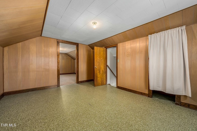 bonus room featuring wooden walls, baseboards, and lofted ceiling