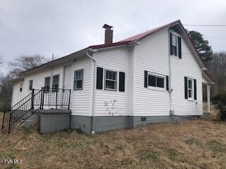 exterior space featuring crawl space and a chimney