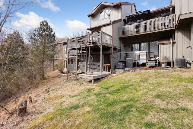 rear view of property with central air condition unit, a lawn, and a wooden deck