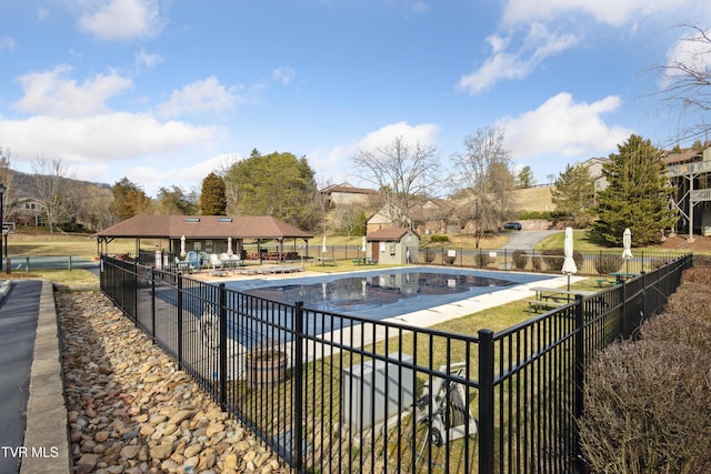 community pool featuring a gazebo, a patio, an outdoor structure, and fence