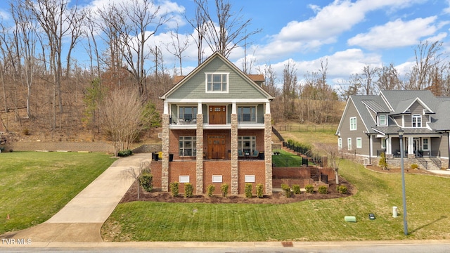 view of front of house with covered porch, a front yard, and a balcony