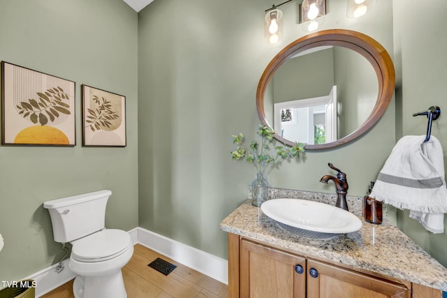 bathroom with vanity, toilet, baseboards, and visible vents